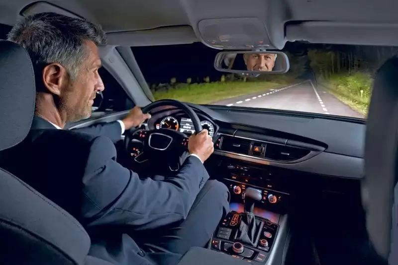 Мужчина едет в автомобиле при свете фар